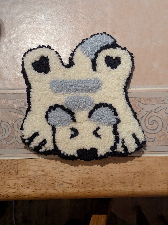 a white and grey cat rug. The cat is spraweled out, like a bear rug
