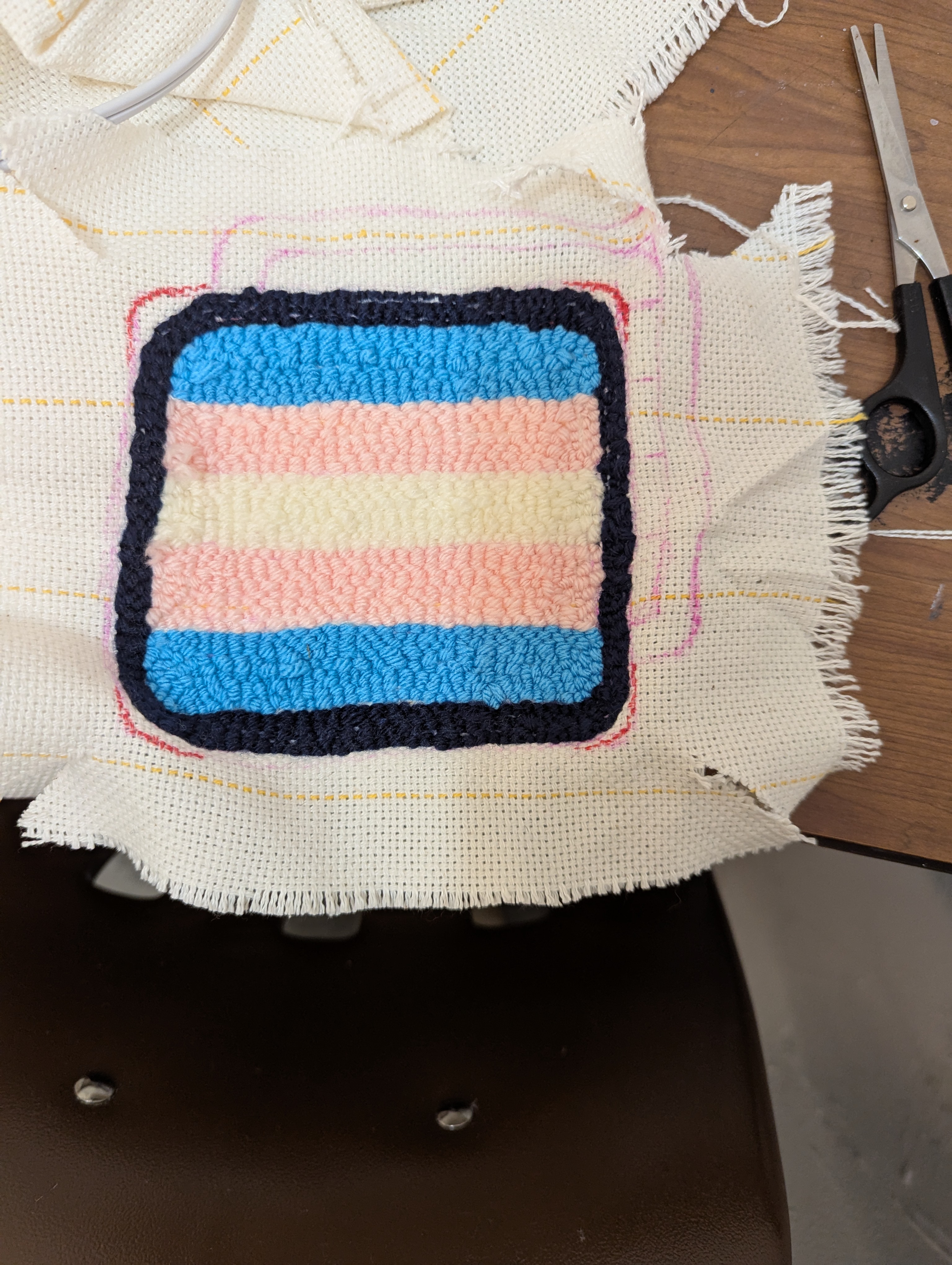 The back stitching of a trans flag rug